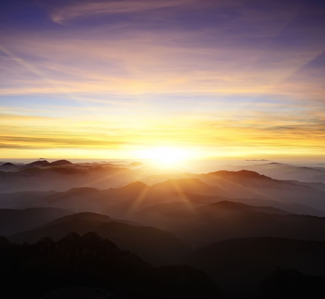 Immagine rappresentante il tramonto del sole tra le montagne